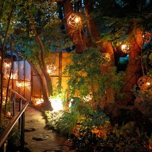 A nighttime garden with illuminated spherical lights, a wooden fence, and a metal staircase. - Kurokawa Onsen Wafu Ryokan Misato (Minamioguni)