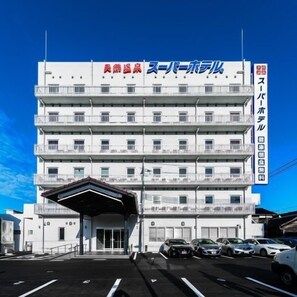 Un edificio de varios pisos con techo plano y entrada cubierta.