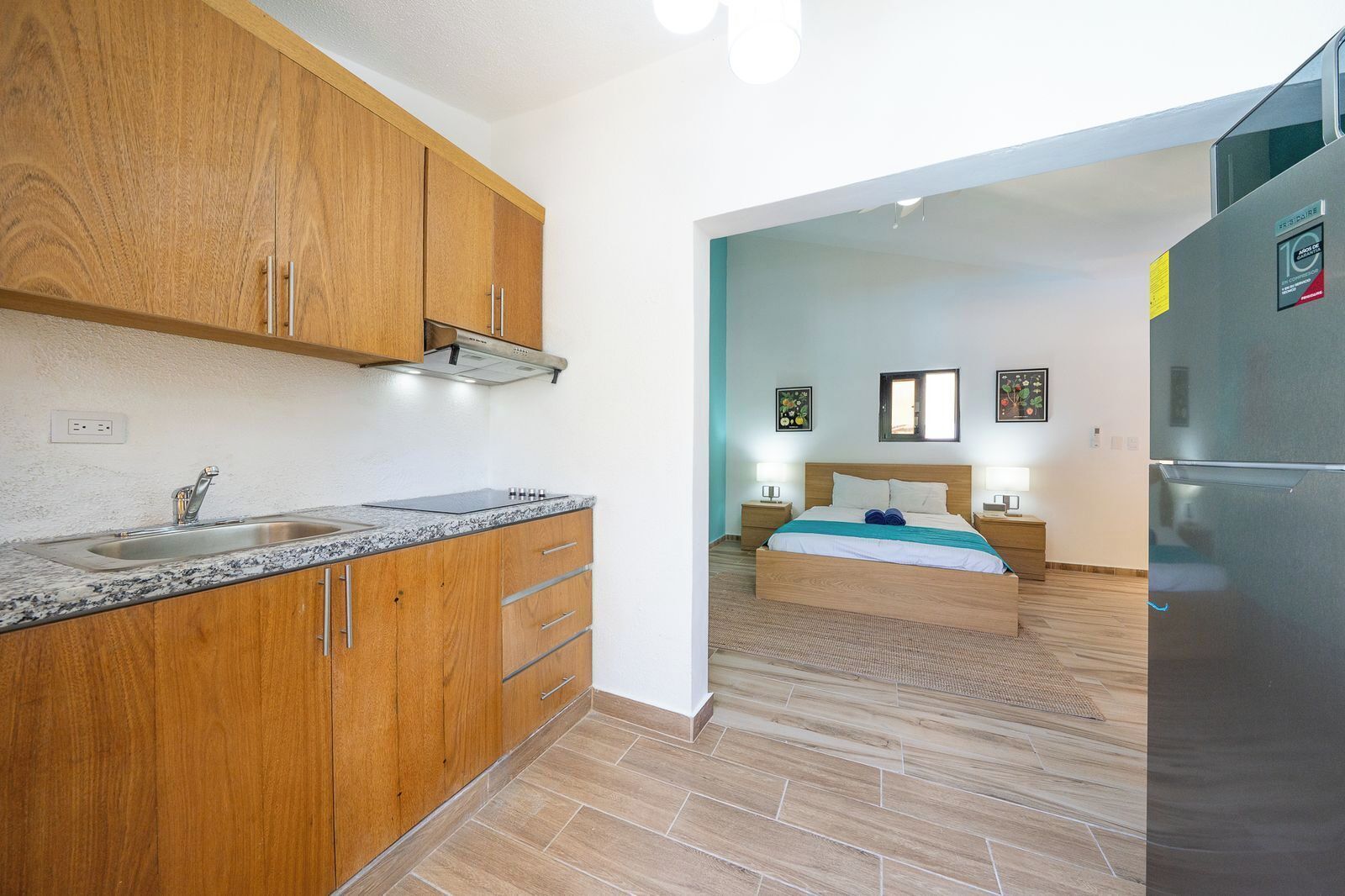 A compact kitchen with wooden cabinets and a stainless steel sink.