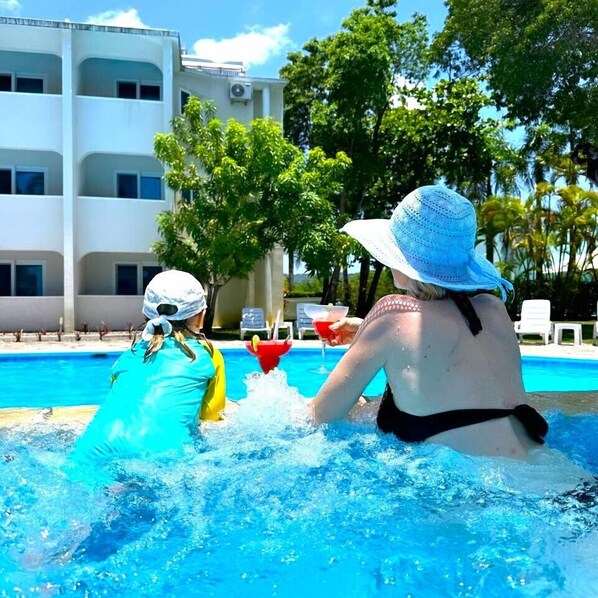 A swimming pool area with a building in the background.