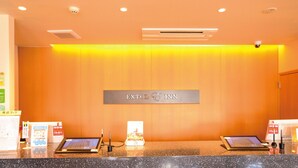 A reception desk with a sign reading "EXTOL INN" and a digital display. - Extol Inn Sanyo Onoda Asa Ekimae (Sanyoonoda)