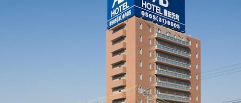 A tall hotel building with a prominent blue sign indicating it is an AB Hotel.