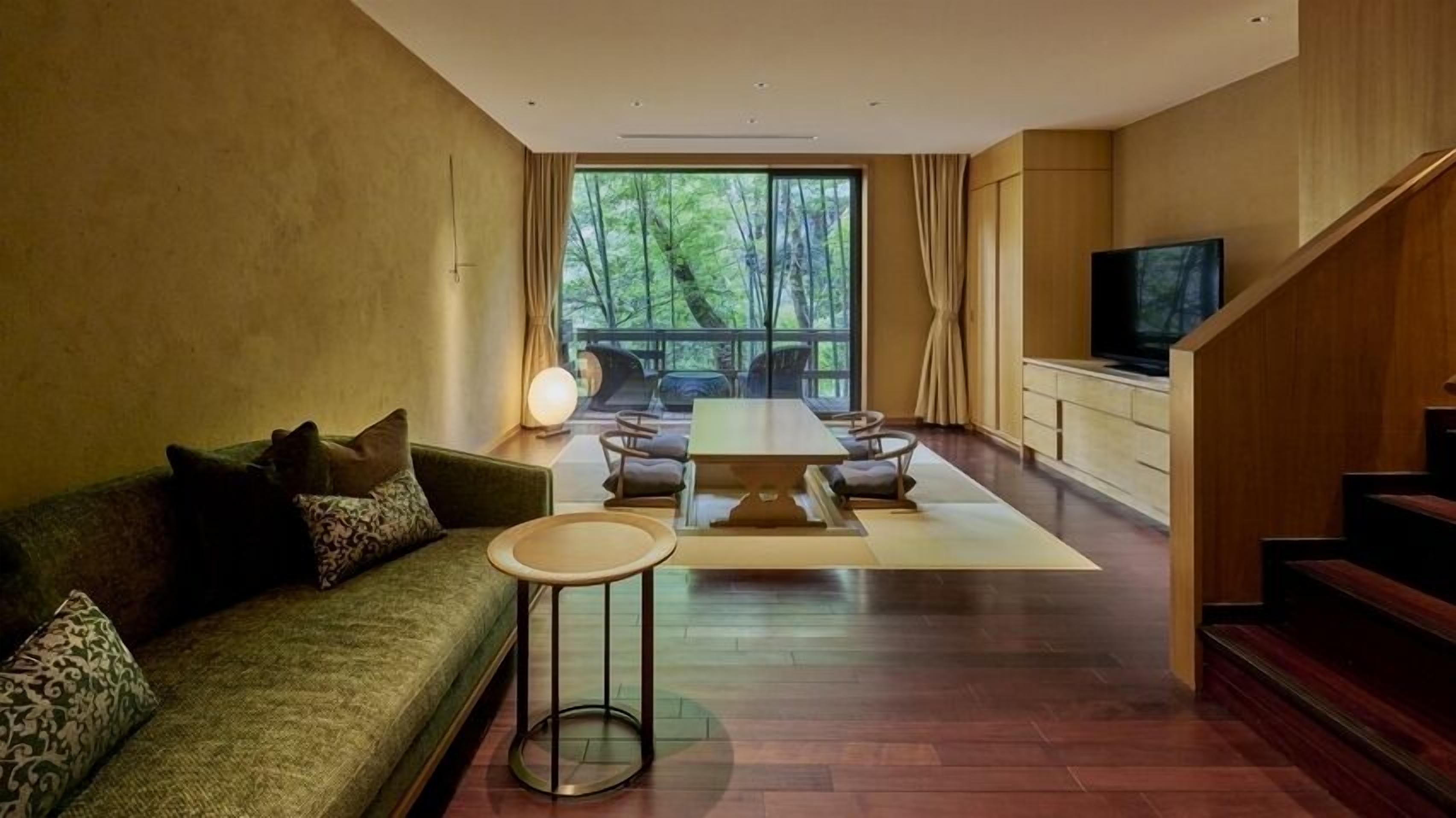 A modern living room with a sofa, coffee table, and dining area.
