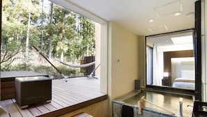 A room with a wooden deck, a glass-walled bathroom, and a view of trees. - Hakone Suishoen (Hakone)