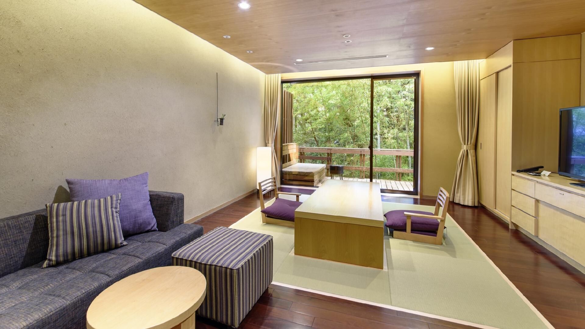 A modern living room with a sofa, a coffee table, a dining area, and a TV.