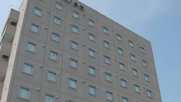 A multi-story building with a uniform facade, numerous windows, and a clear sky.