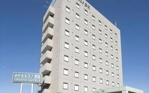 Ett hotell med flera våningar, och en skylt som visar att det tillhör hotellkedjan Greens Hotels.