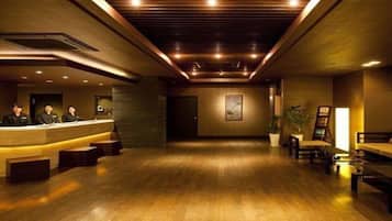 A reception area with a wooden floor, a reception desk, and a wall-mounted painting.