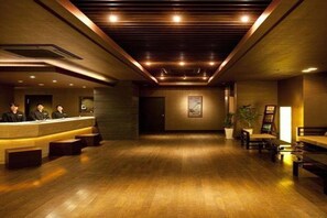 A reception area with a wooden floor, a reception desk, and a wall-mounted painting.