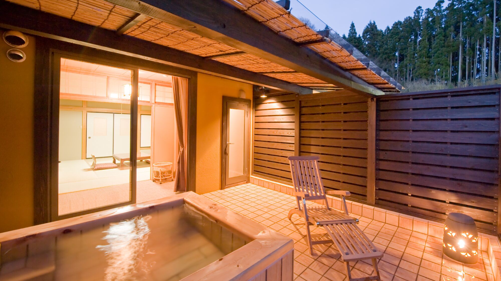 Ein Whirlpoolbereich mit Holzterrasse, einem Stuhl und einem kleinen Tisch.