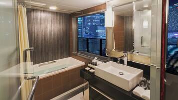 A modern bathroom with a bathtub, a sink, and a large mirror.