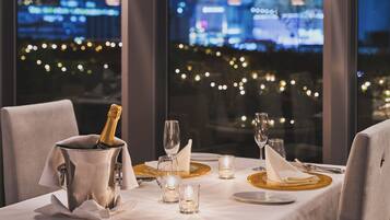 A table set for a meal with a bottle of champagne, glasses, and candles.