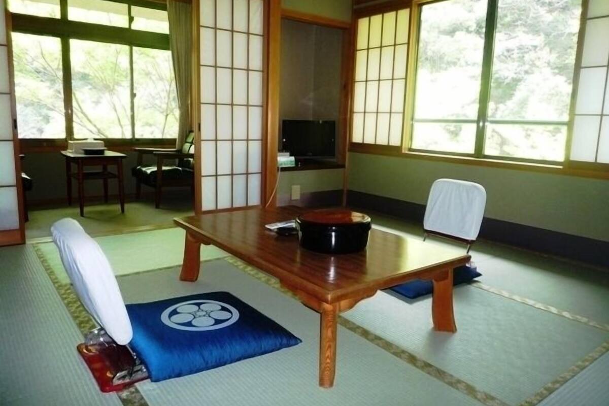 Una habitación japonesa tradicional con suelo de tatami, una mesa de madera baja y un panel shoji.