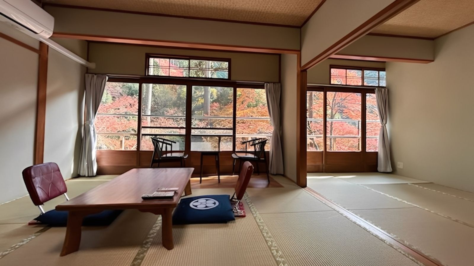 Um quarto japonês tradicional com tatames, uma mesa baixa e cadeiras.