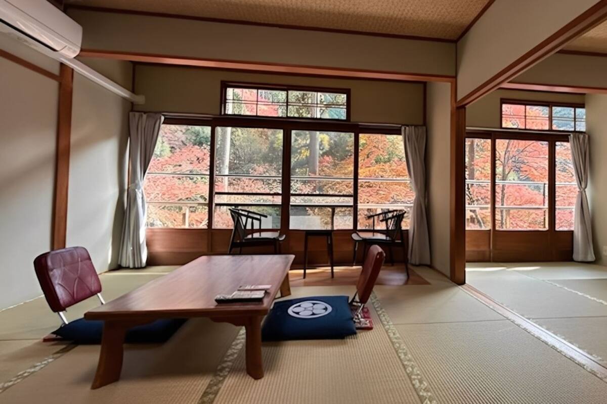 Una habitación japonesa tradicional con suelo de tatami, una mesa baja y sillas.