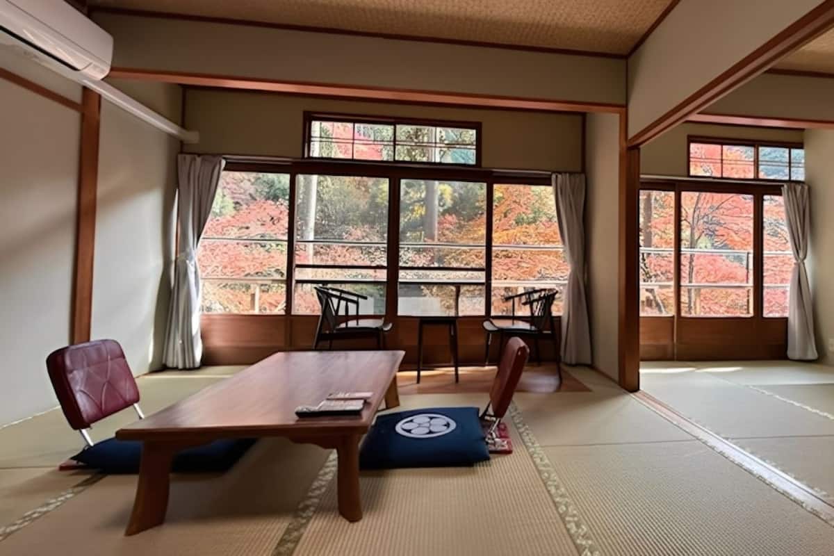 A traditional Japanese room with tatami flooring, a low table, and chairs.