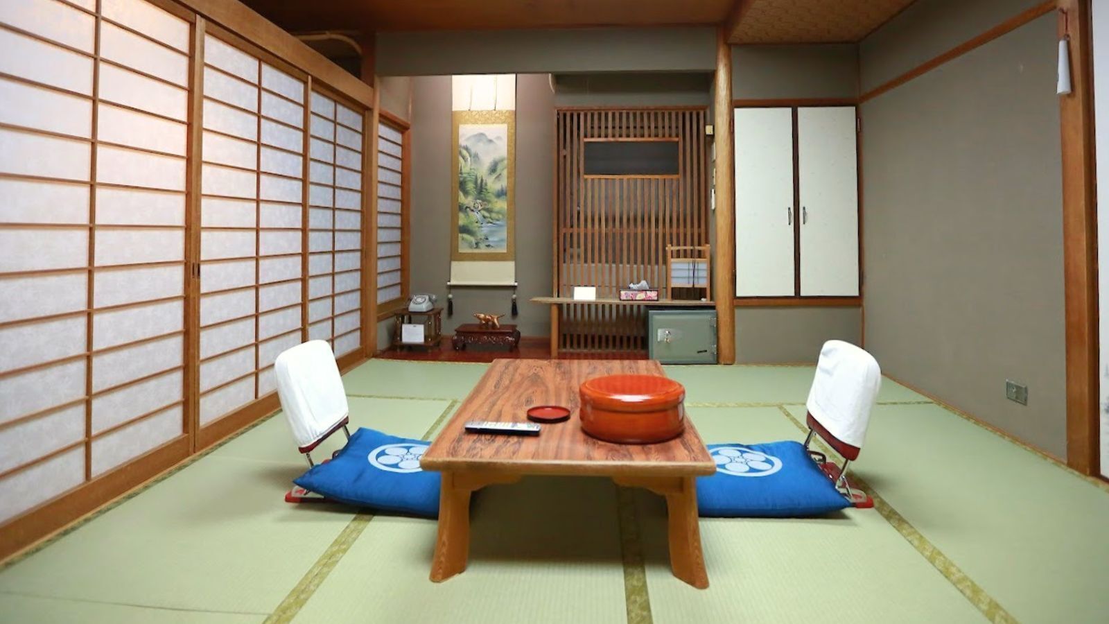 Um quarto japonês tradicional com tatames, uma mesa de madeira baixa e biombos shoji.