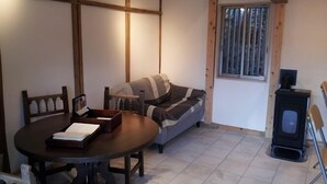 Ein gemütlicher Raum mit Holztisch, einer Couch und einem Kamin.