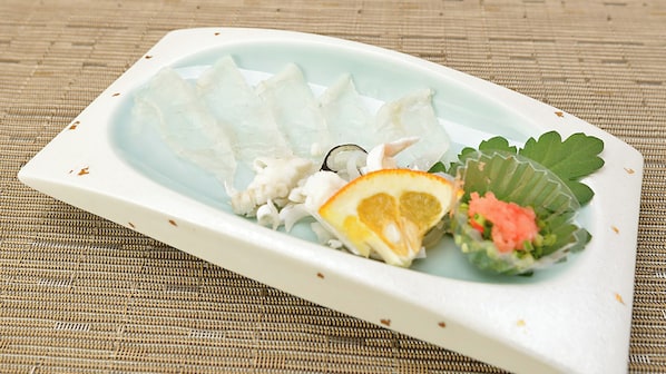 A white plate with food items on a textured surface. - Shisuien (Shunan)