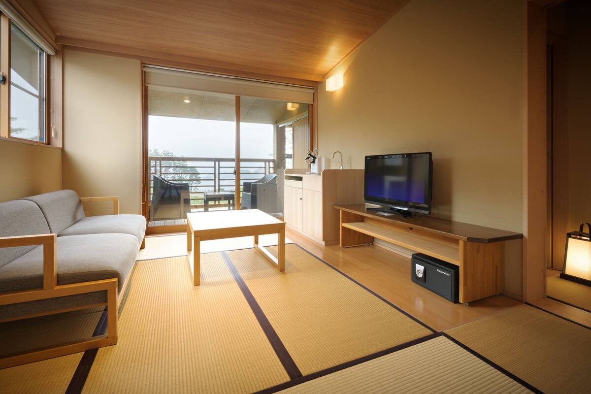A modern living room with a sofa, a TV, and a dining table.