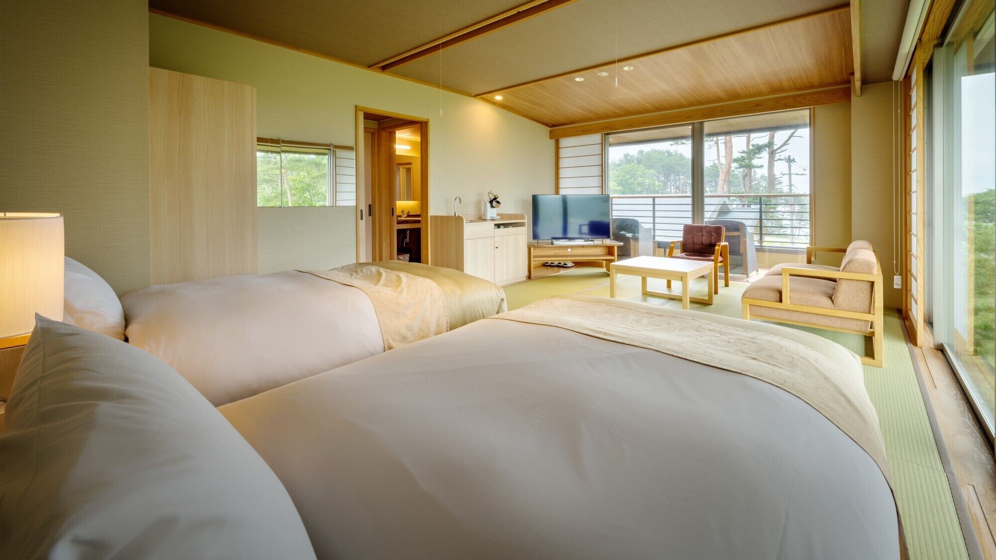Une chambre d’hôtel avec deux lits, une télévision, un bureau et une chaise.