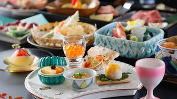 Una variedad de platos y alimentos en una mesa, incluyendo mariscos, verduras y posiblemente sushi.