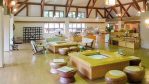 A spacious lobby with wooden beams, a reception desk, seating areas, and a kitchen in the background. - Azuki Onsen Kaboku no Yado (Minamiaizu)