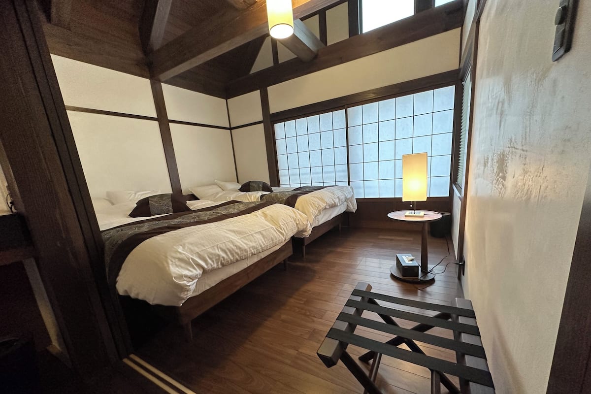 A traditional Japanese-style room with tatami flooring, a low table, and a sliding door.