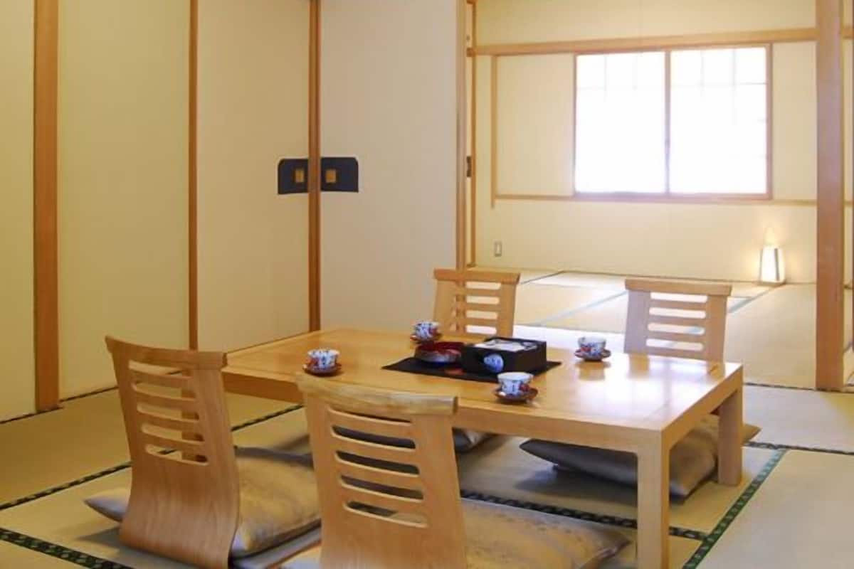 A traditional Japanese room with tatami flooring, a low wooden table, and sliding doors.