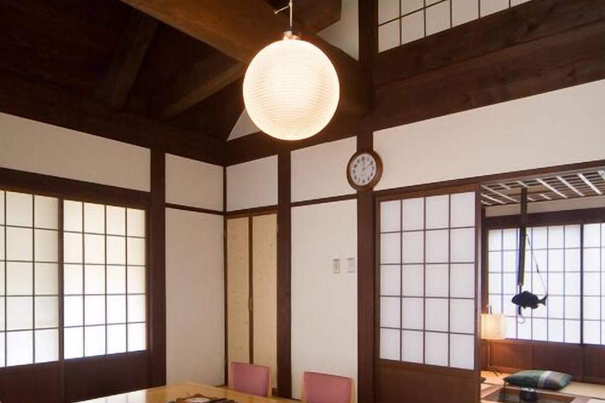 A traditional Japanese room with tatami flooring, a low wooden table, and shoji screens.