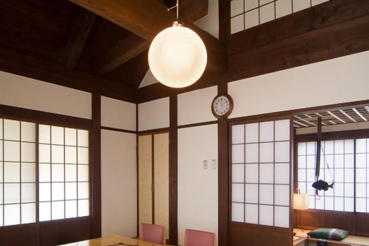 Et traditionelt japansk rum med tatamimåtter, et lavt træbord og shoji-skærme.