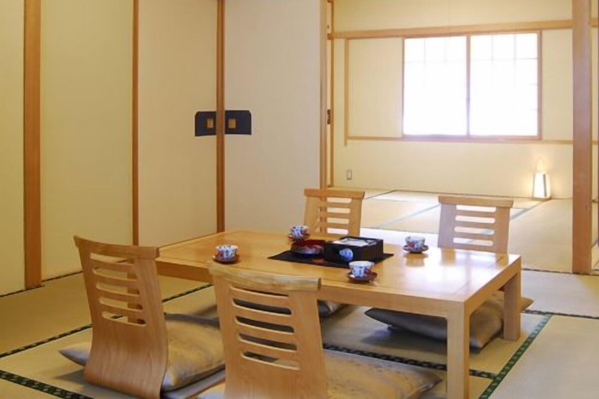 A traditional Japanese room with tatami flooring, a low wooden table, and sliding doors.