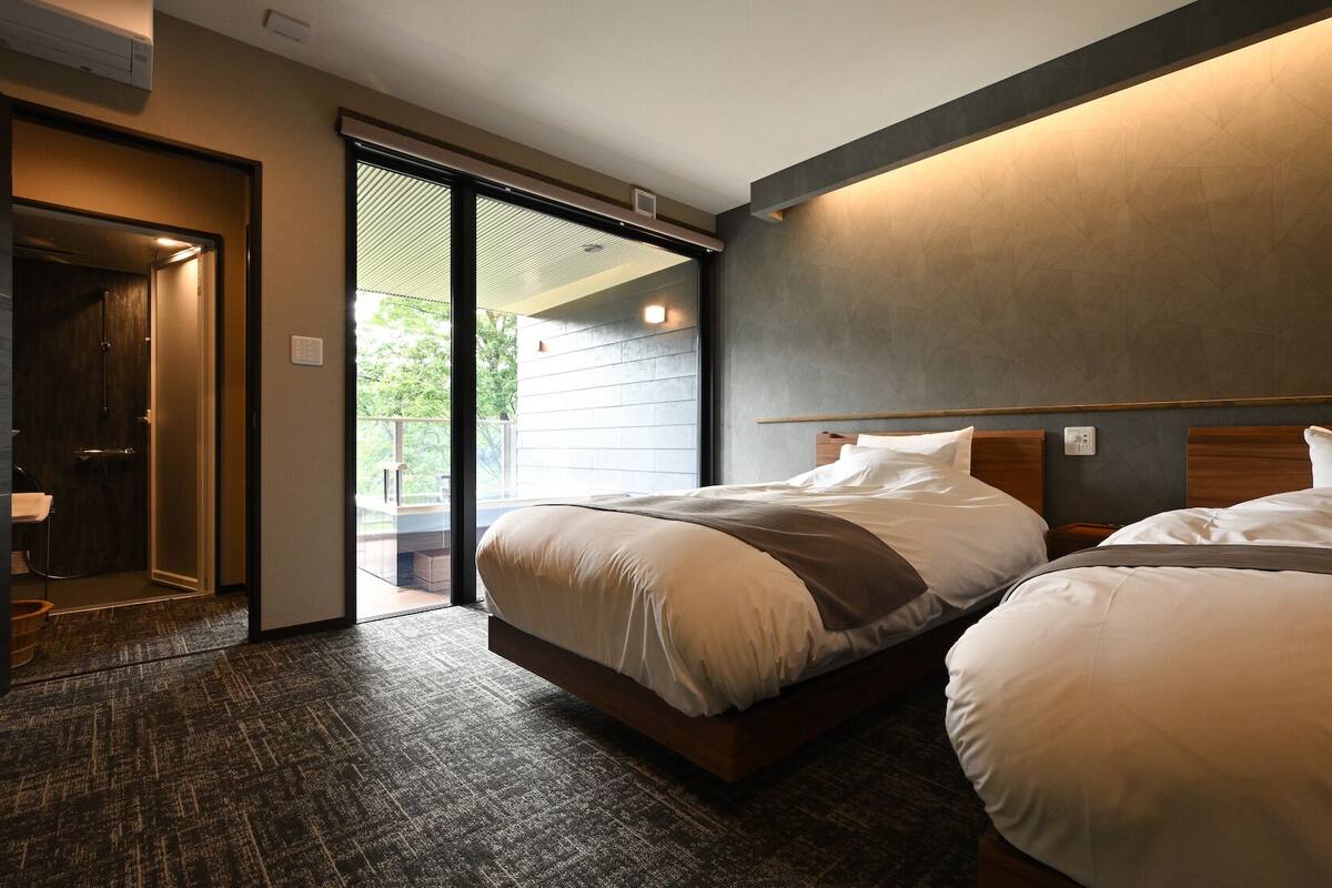 Ein Hotelzimmer mit Bett, Badezimmer und einer Schiebetür zum Außenbereich.