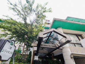 A hotel entrance with a modern design, including a glass facade and a sign for the Mieka City Hotel. - Mitaka City Hotel (Mitaka)