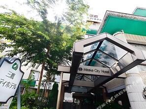 A modern hotel entrance with a glass facade and signage for 'Mikasa City Hotel'. - Mitaka City Hotel (Mitaka)
