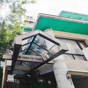 Esterno dell'Hotel Mitaka City, con un ingresso in vetro moderno e un tetto verde.
