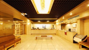 A hotel lobby with a reception desk, seating area, and a large illuminated ceiling. - Mitaka City Hotel (Mitaka)