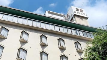 A multi-story building with a flat facade, multiple windows, and a green awning.