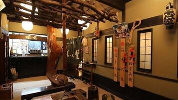 A traditional Japanese interior with wooden beams, tatami flooring, and shoji screens.