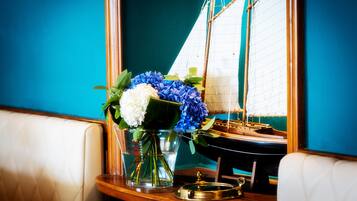 A table with a vase of flowers, a ship model, and a brass key.