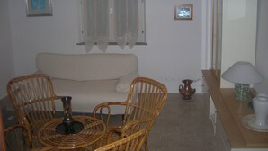 A living room with a sofa, wicker chairs, a table, and a lamp. - HOUSE FOR RENT IN THE COUNTRYSIDE  (MONTE GIOVE)