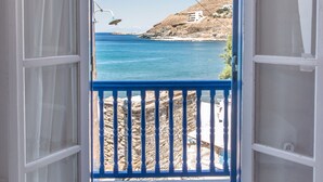 An open door leading to a balcony with a view of a coastal landscape. - Luxury Wave  Maisonette Ormos Isternion Tinos (Tinos)