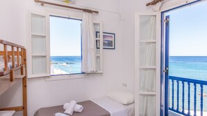 A room with a bed, a window with curtains, a view of the sea, and a balcony with a railing. - Luxury Wave  Maisonette Ormos Isternion Tinos (Tinos)