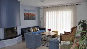 A living room with a fireplace, a sofa, a coffee table, and a chair.