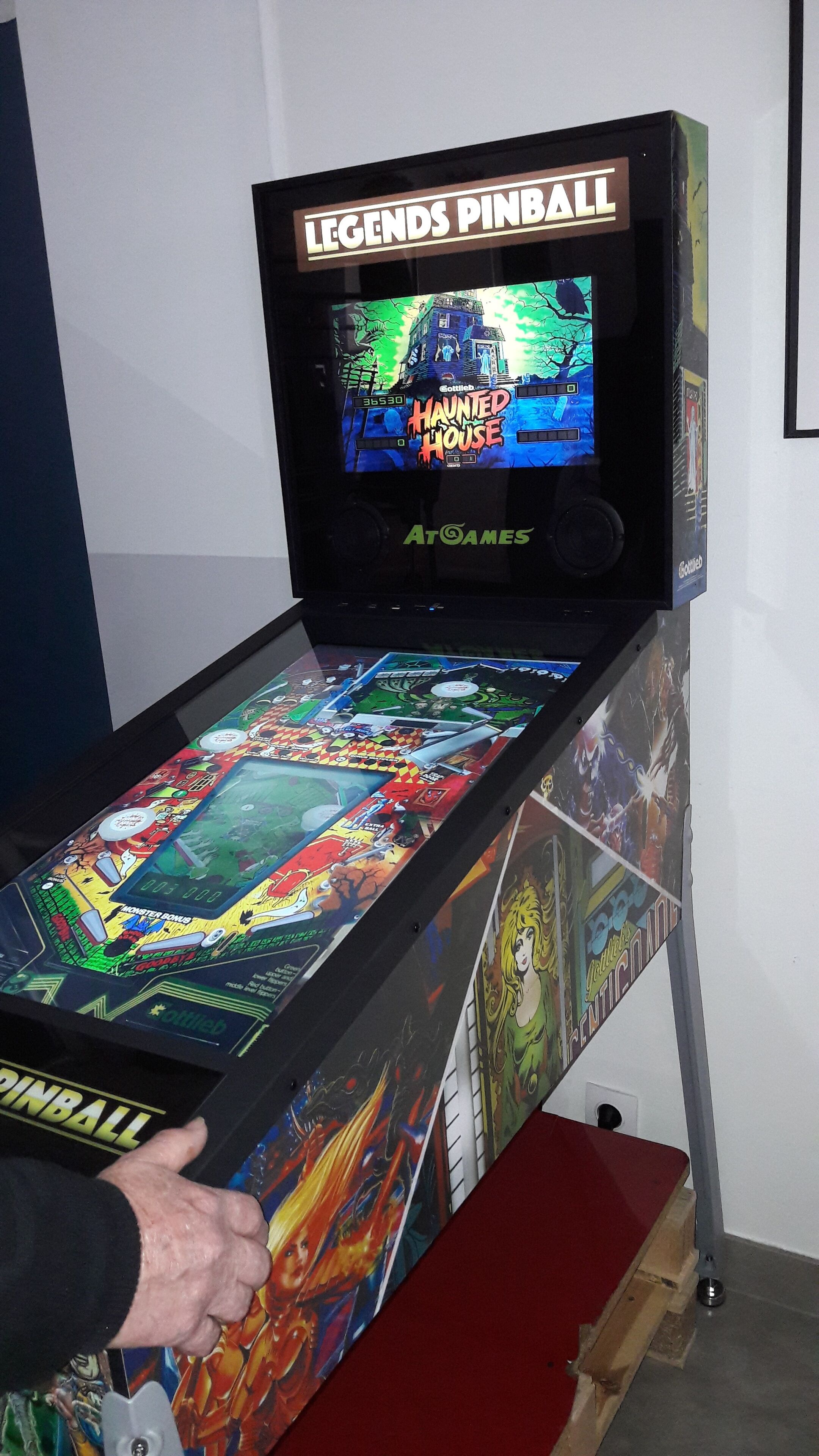 Un flipper intitulé « Legends Pinball », sur le thème d’une « maison hantée », avec divers éléments de jeu colorés et un écran d’affichage des scores.