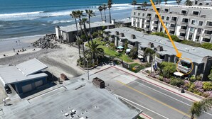 A coastal hotel with a parking lot, beach access, and a view of the ocean. - Great corner condo! Surrounding Ocean Views - D2 North Coast Village (Oceanside)