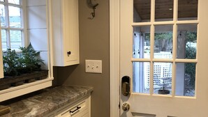 A kitchen with white cabinets, a marble countertop, and a door with a window. - Kentucky at its best! Historical meets modern amenities! (Louisville)