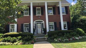 A two-story brick building with a central entrance, columns, and a symmetrical facade. - Kentucky at its best! Historical meets modern amenities! (Louisville)