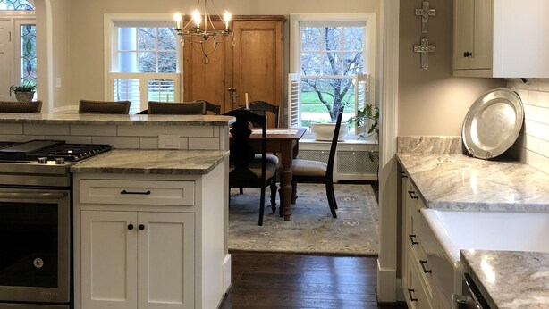 A spacious kitchen with a large island, wooden cabinets, and a dining area with a table and chairs. - Kentucky at its best! Historical meets modern amenities! (Louisville)
