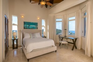 A bedroom with a bed, a desk, and a painting on the wall.